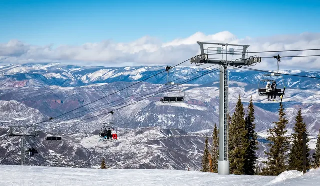 Skiers and snowboarders ascend the Elk Camp chairlift at the Aspen Snowmass ski resort