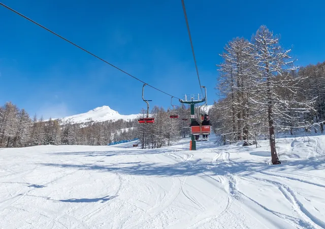 Bardonecchia, Italian Alps, snowy scenery: ski slopes and chairlift (chair lift), ski resort and winter snow landscape.