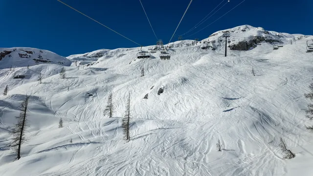 Colere, Italy. Chairlift with skiers is moving to the top of the ski runs in a wonderful sunny day