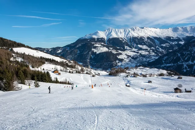 Slope and yellow gondolas in ski resort Serfaus Fiss Ladis in Austria with snowy mountains